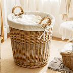 Panier à linge en bois rond dans une chambre avec du linge dedans 