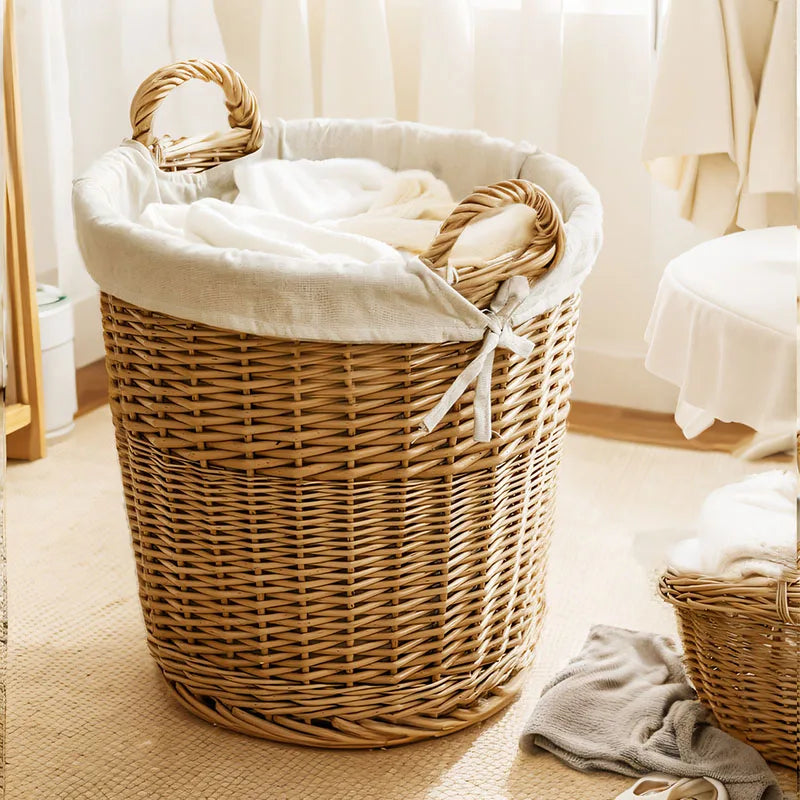 Panier à linge en bois rond dans une chambre avec du linge dedans 