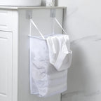 Panier à linge suspendu tout blanc dan une salle de bain avec du linge dedans 