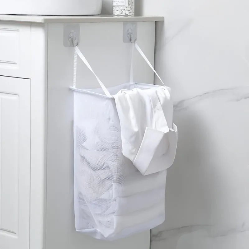 Panier à linge suspendu tout blanc dan une salle de bain avec du linge dedans 