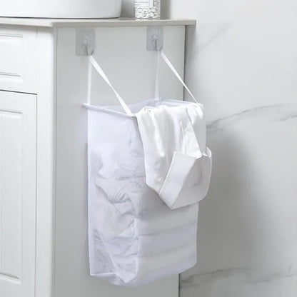 Panier à linge suspendu tout blanc dan une salle de bain avec du linge dedans 